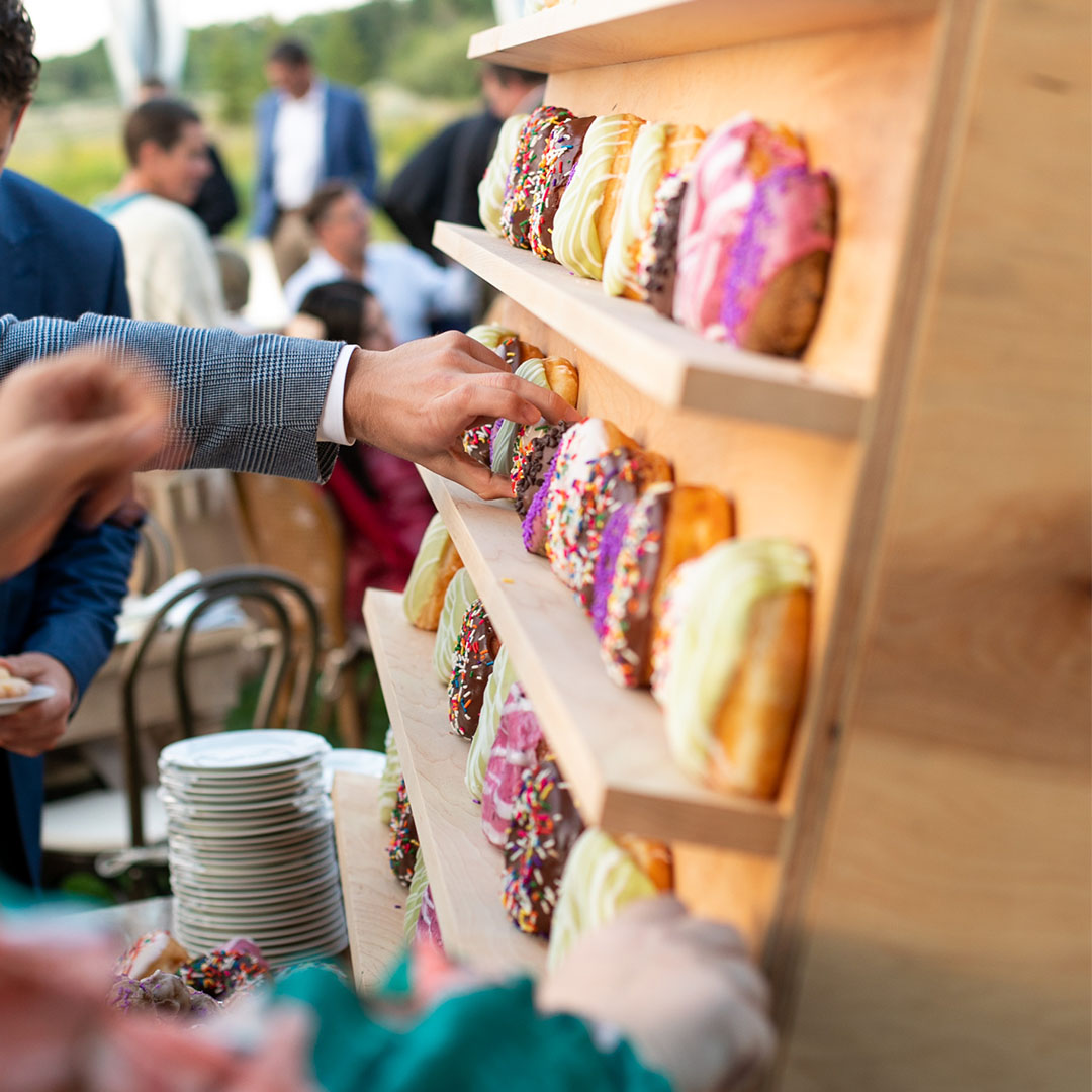 Wedding guest holding a plate of stacked house-made Provisions donuts