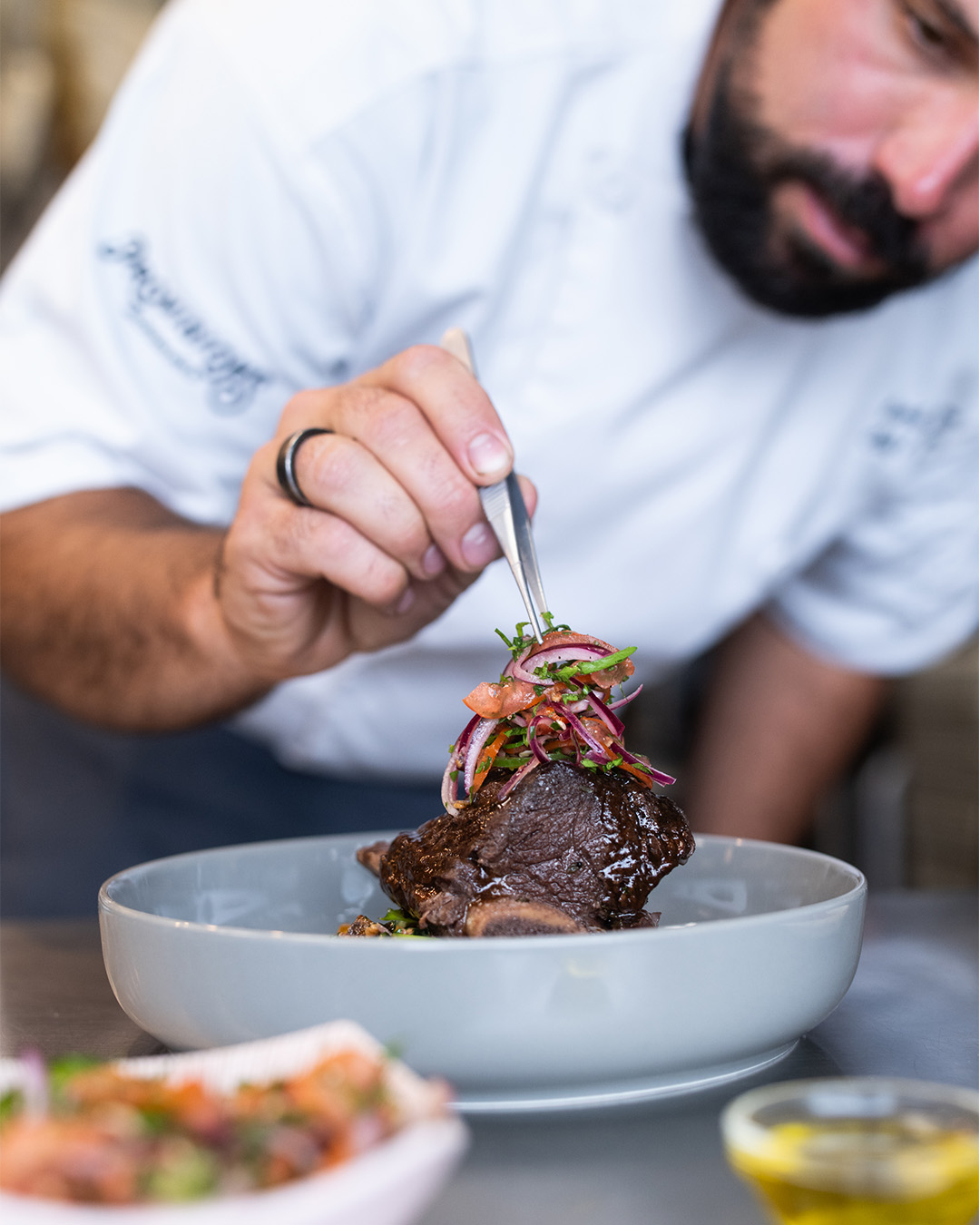 Chef presenting crispy bites on pesto for a private dinner
