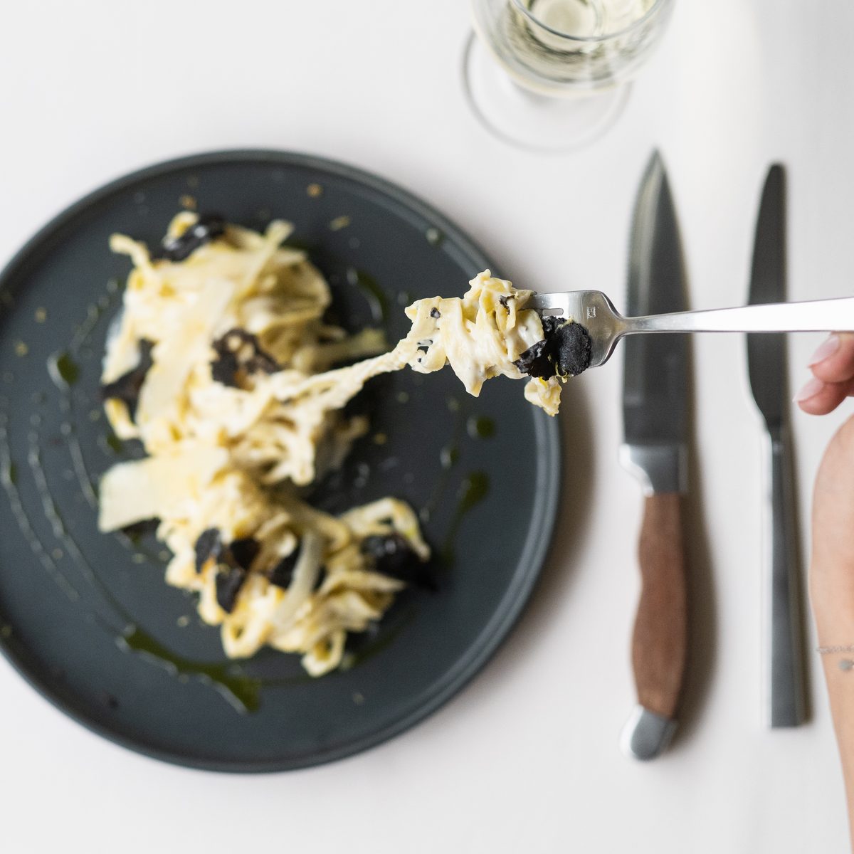 Guest twirling fresh tagliatelle with truffle at a private birthday dinner