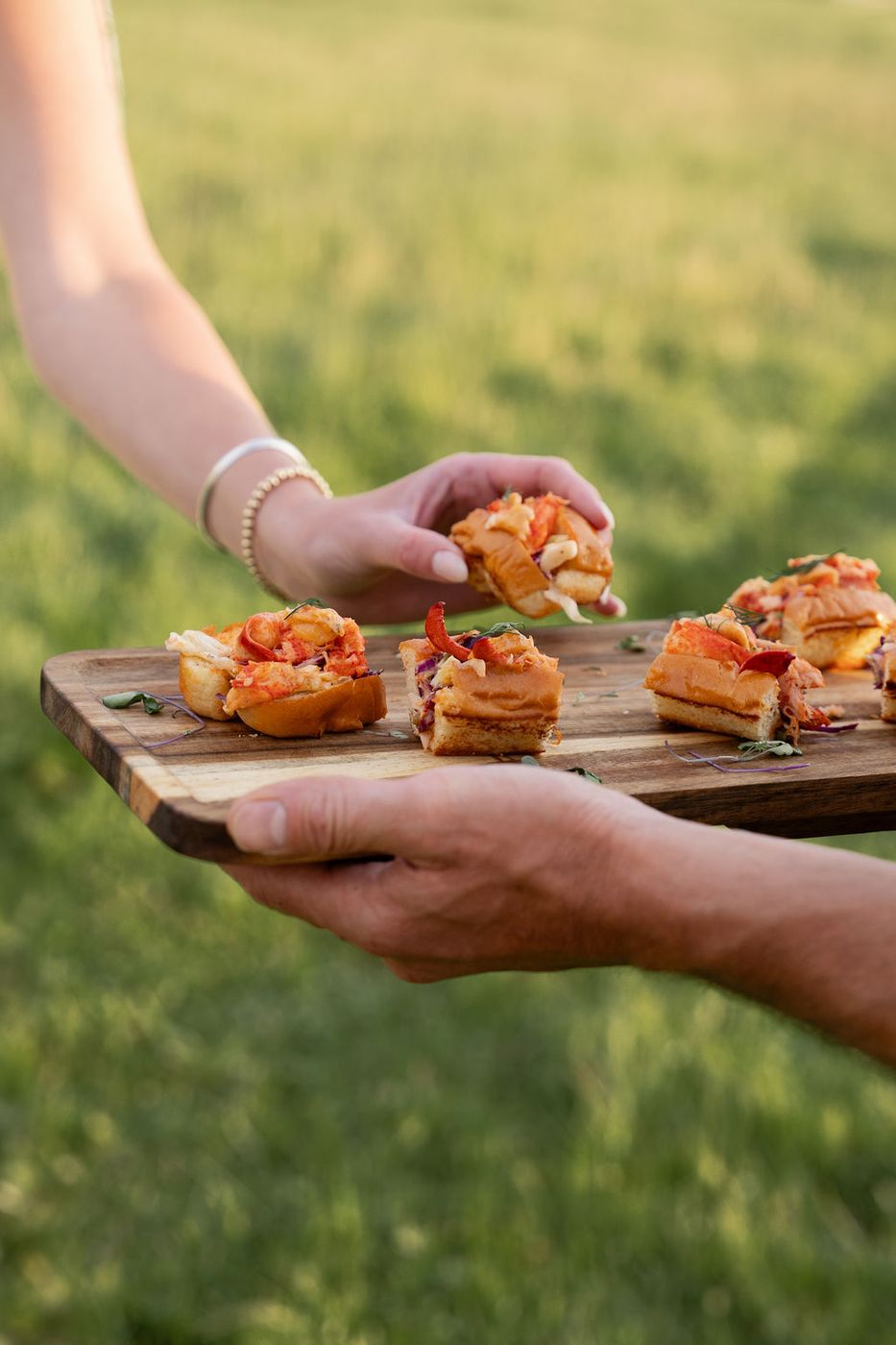 Guest taking bruschetta from a wooden board