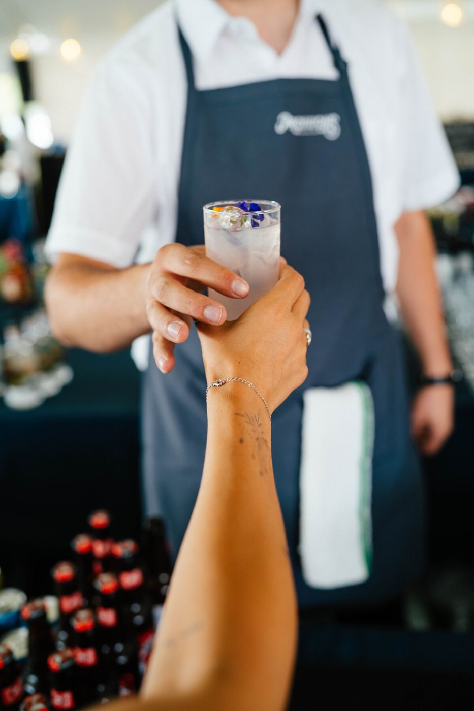 Server handing a cocktail to a guest