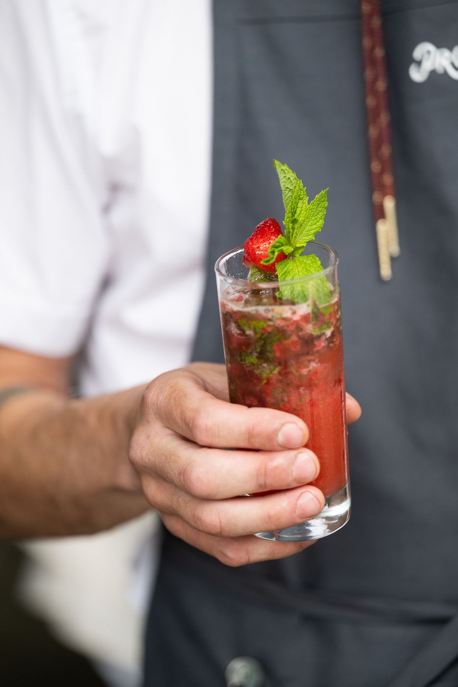 Server holding a strawberry mint cocktail