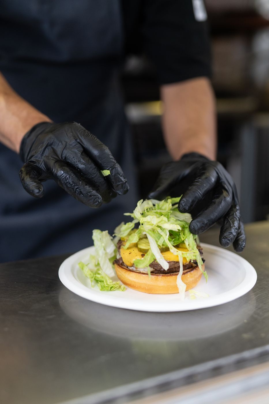 Chef assembling a burger