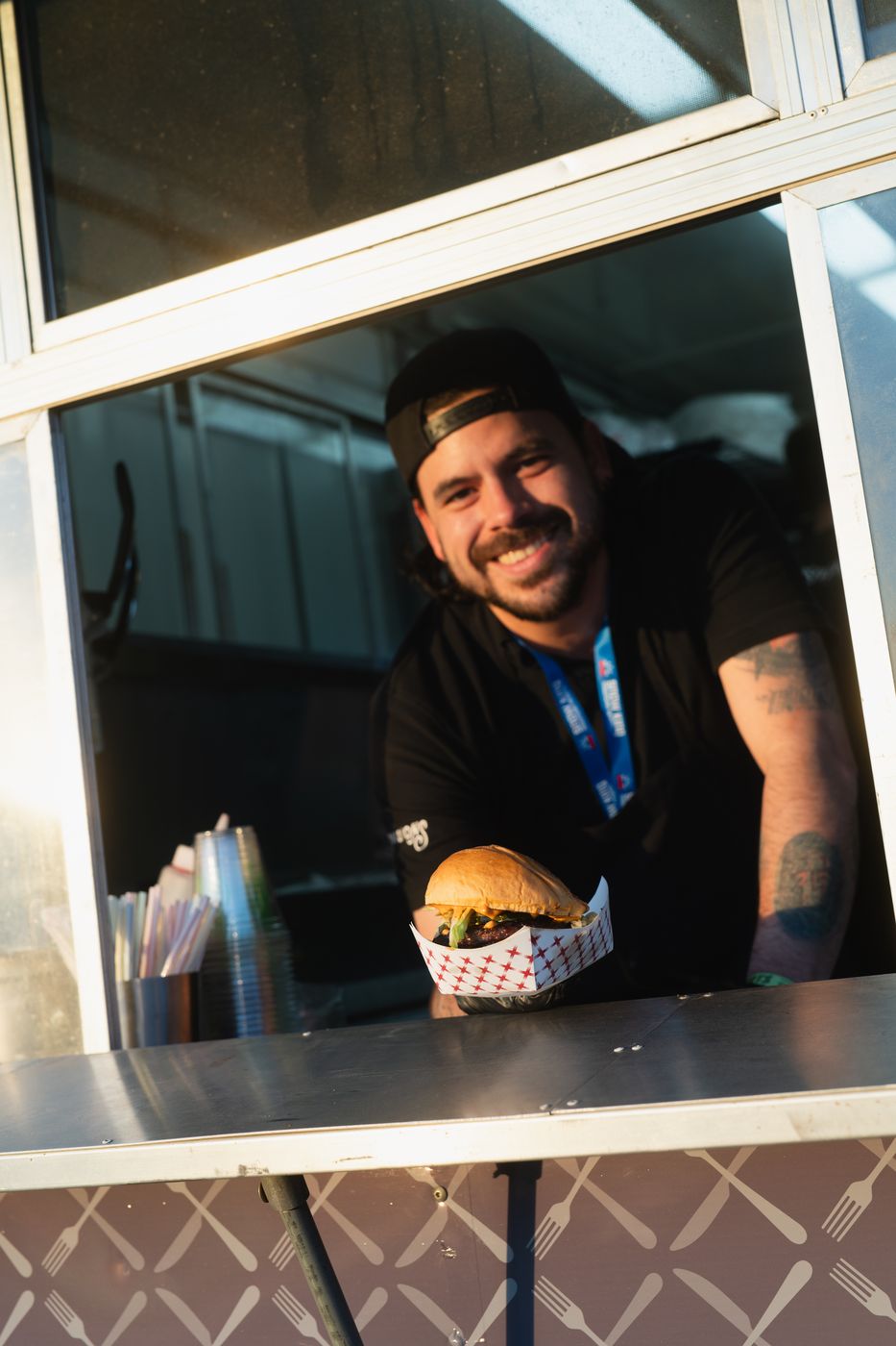Smiling chef handing a burger out the window