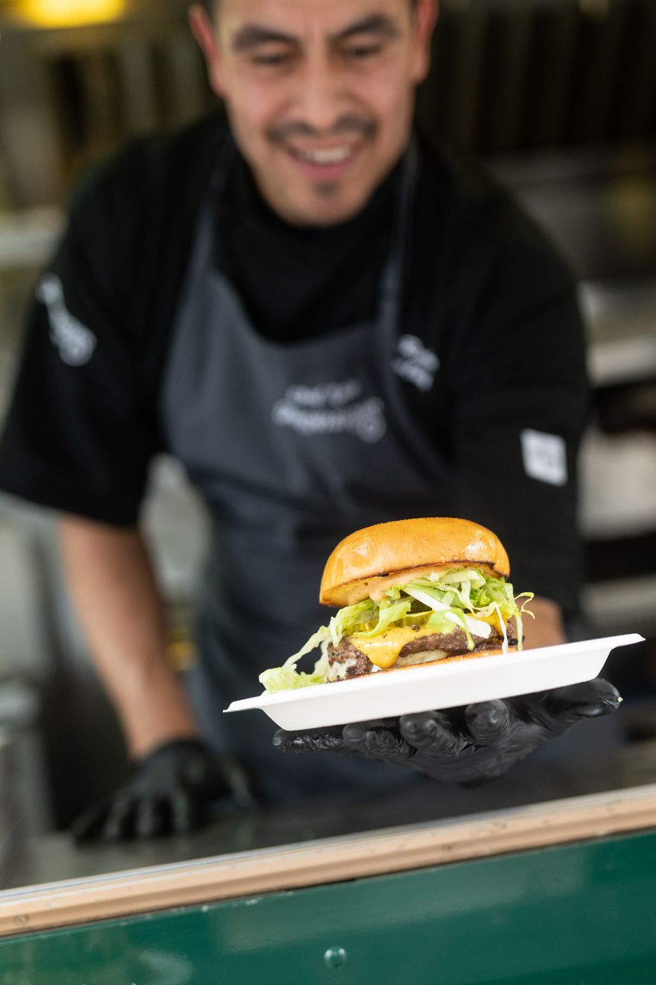 Chef holding a burger at the truck window
