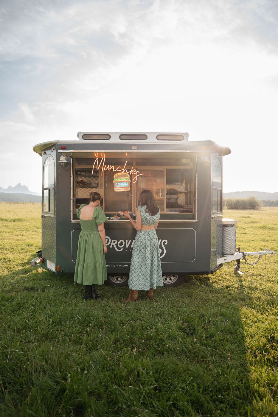 Two guests at the food truck in a meadow