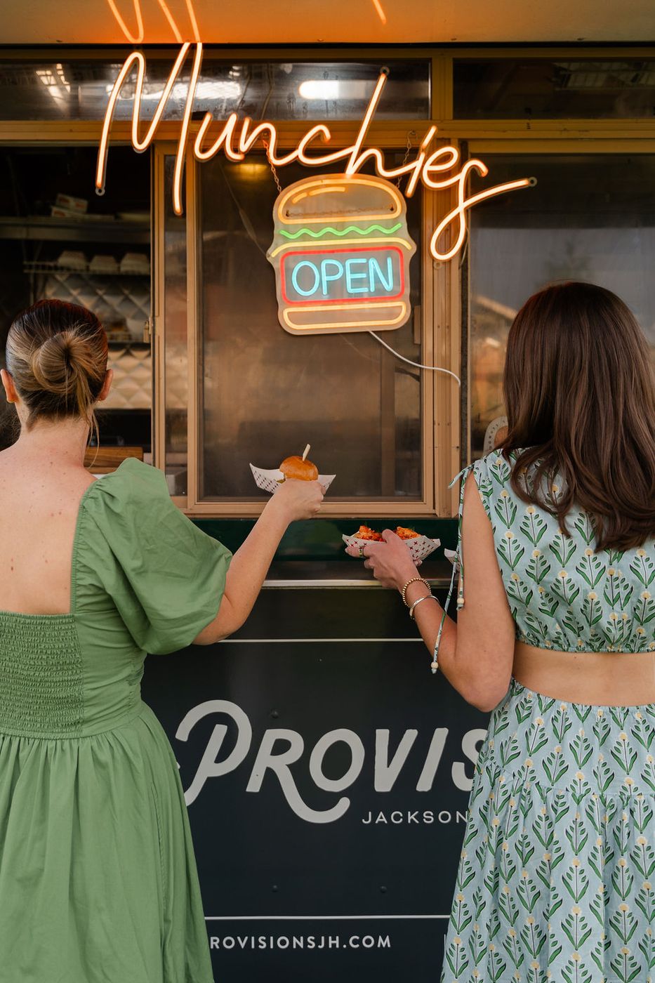 Guests ordering under the neon sign at the truck window