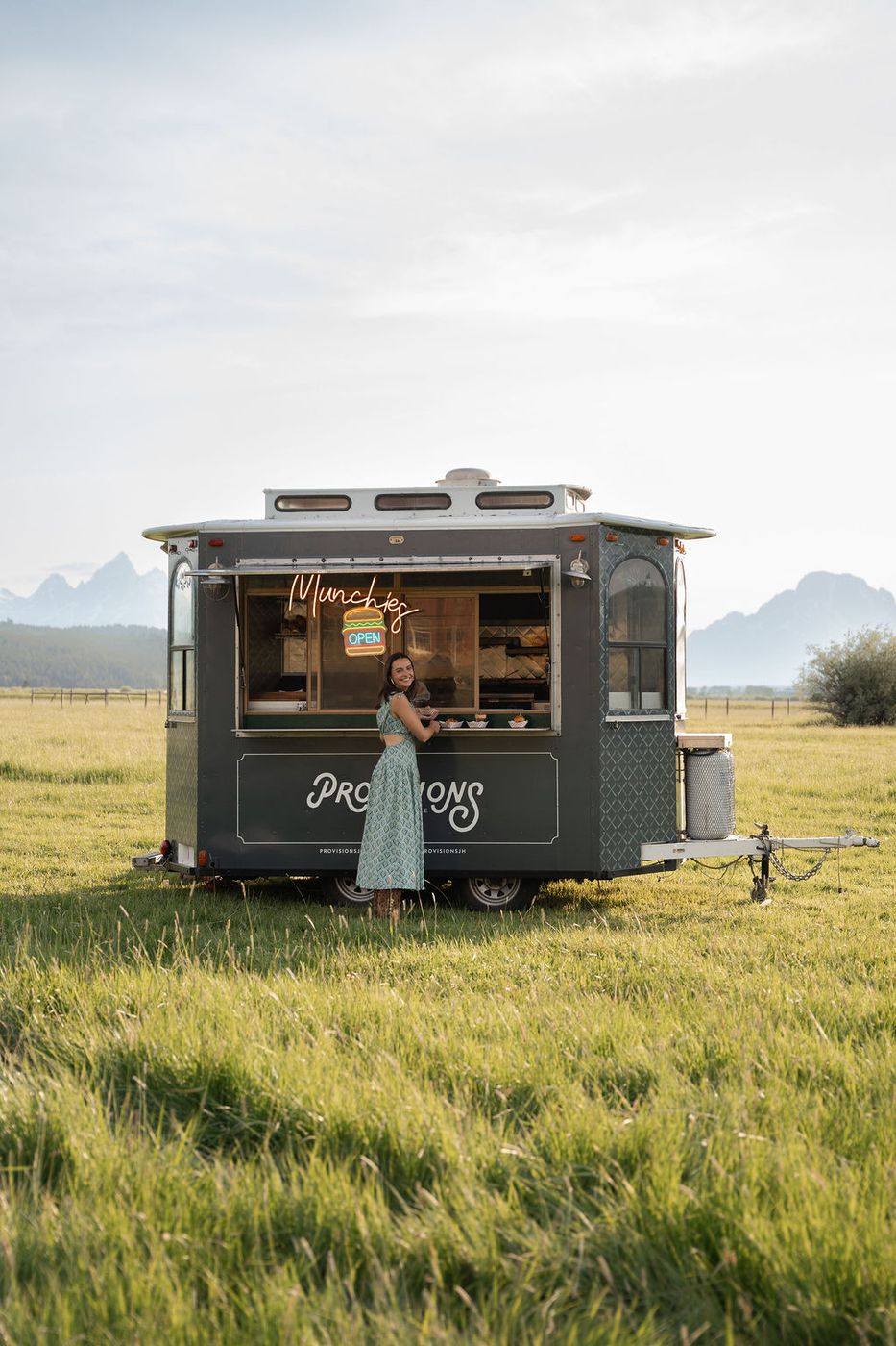 Provisions food truck in a meadow with the Tetons behind
