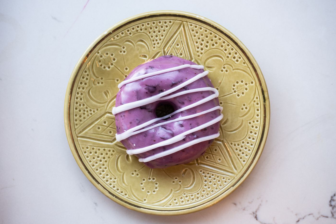 Blueberry glazed donut on a green plate