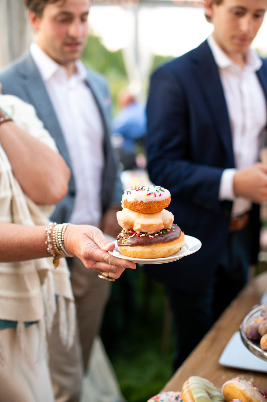 Wedding guest holding a plate of stacked donuts