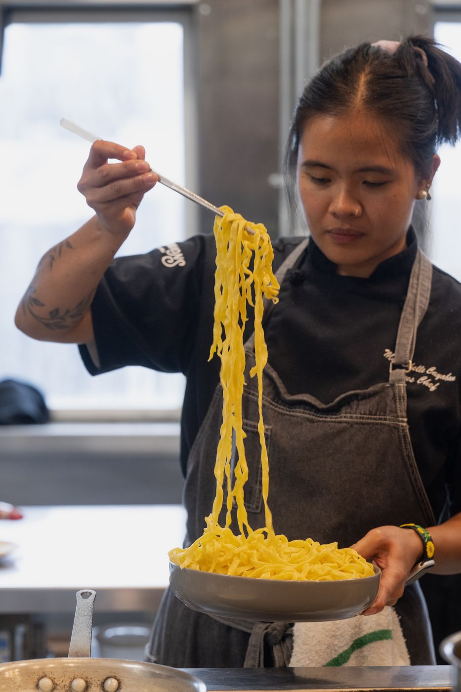 Chef lifting fresh tagliatelle