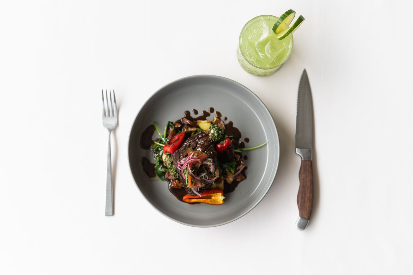 Short rib at a place setting with a cocktail
