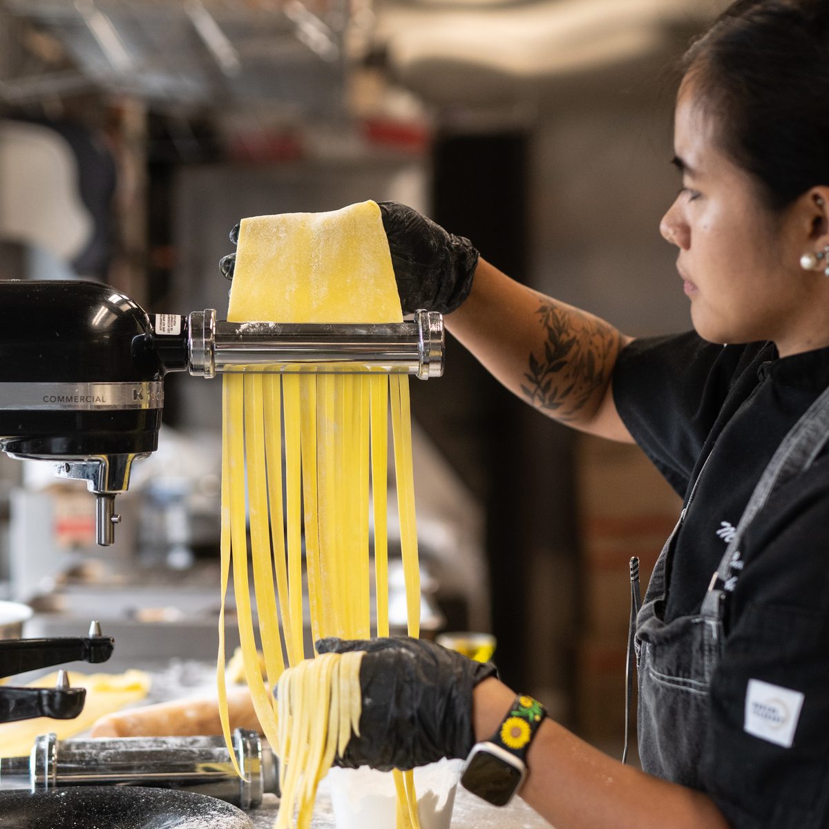 Provisions private chef rolling fresh pasta through a pasta maker