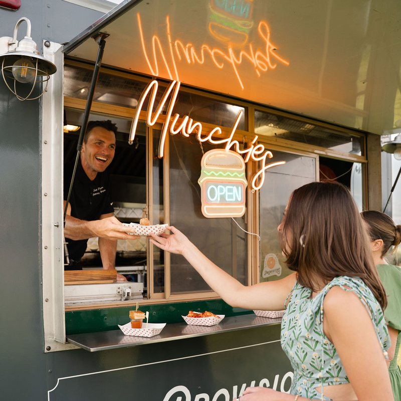 Server carrying a plate of sliders from a Provisions food truck at a private event