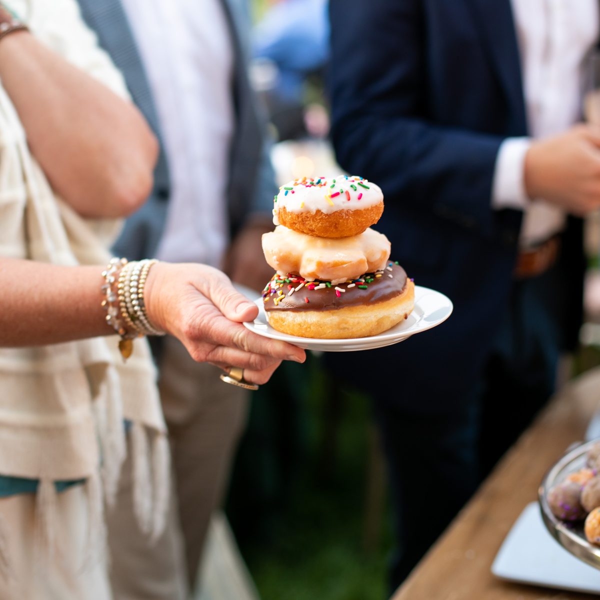 Wedding guest holding a plate of stacked Provisions donuts